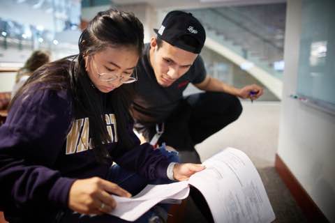 two people reviewing a printed document