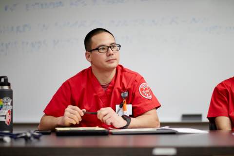 a nursing student writing in a notebook